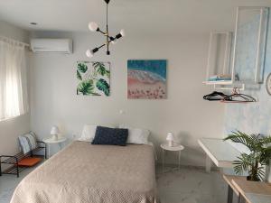 a bedroom with a bed and a desk with two tables at The Sky Yard Eclectic Studios in Rhodes Town