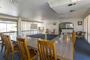 Mid City Motor Inn في ماكاي: غرفة طعام مع طاولة وكراسي خشبية كبيرة