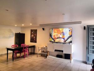 uma sala de estar com uma mesa e uma televisão na parede em Location maison avec piscine privée. em Agde