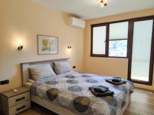 a bedroom with a bed with two towels on it at Апартаменти за гости Делукс in Burgas City
