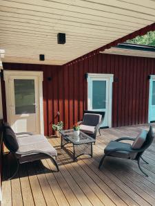 een houten terras met stoelen en een tafel erop bij Emakaru Puhkemaja in Otepää