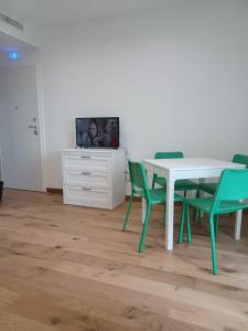 een eetkamer met een tafel en stoelen en een tv bij TRAVERSA I APARTMENT in Bari