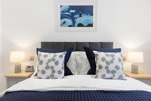 Schlafzimmer mit einem Bett mit blauen und weißen Kissen in der Unterkunft Out to Sea, 8 Grand Banks in Teignmouth