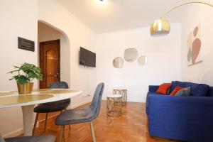 salon z niebieską kanapą i stołem w obiekcie Re di Roma - Charme Apartment w Rzymie