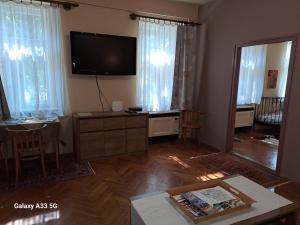 sala de estar con TV de pantalla plana en la pared en Széll 3 Apartman en Szombathely