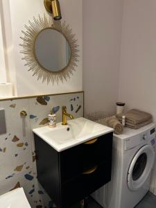 łazienka z umywalką i pralką w obiekcie Nowy Apartament Lipowa w Hajnówce