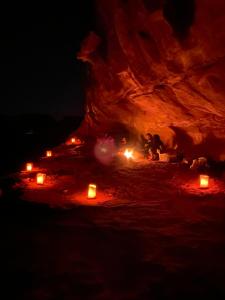 a group of people sitting around a bonfire at night at Wadi Rum Bedouin Heart in Wadi Rum
