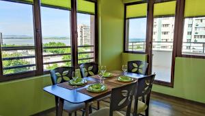 a dining room with a table and chairs and windows at Апартаменти за гости Делукс in Burgas City
