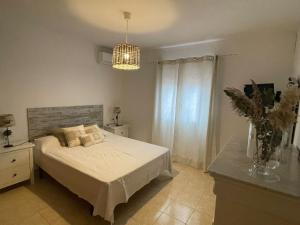 a bedroom with a bed and a chandelier at Casa Marieta in Benissa