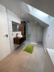 a bathroom with a glass shower and a sink at LOFTYy in Stoumont
