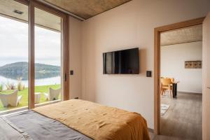 1 dormitorio con 1 cama y TV en la pared en Wa One Lake Homes en San Carlos de Bariloche