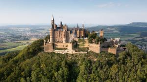 an castle on top of a hill with trees at Stauffenberg Apartments in Albstadt