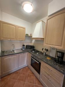 - une cuisine avec des placards en bois, un évier et une cuisinière dans l'établissement CS Holiday, à Castelnuovo Berardenga