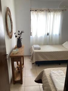 a room with two beds and a table and a window at Pacífico Il in Cordoba