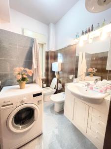 a bathroom with a washing machine and a sink at Home and Relax ROOMS in Furnari