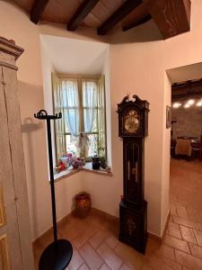 a grandfather clock in a room with a window at Casa Banino in Cagli