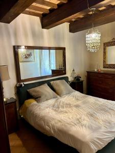 a bedroom with a large bed and a chandelier at Casa Banino in Cagli