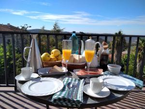 una mesa con platos de comida y bebida en el balcón en Restaurante & Hotel Rural El Mirador de Trevejo en Villamiel
