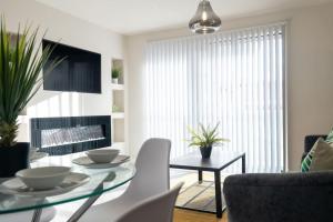 a living room with a glass table and a couch at Century Central, Cardiff Bay, Modern Chic 2BR, Free Parking in Cardiff