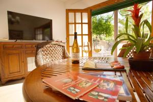 a wooden table with a bottle of wine on it at Villa Cultural MONTELUCÍA in Montecorto