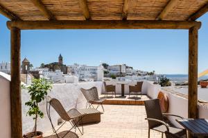a balcony with chairs and a view of the city at Casa Lunarito in Vejer de la Frontera