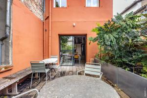 un edificio naranja con una mesa y sillas en un patio en Maison les 3 perles - Hypercentre - Gaillac, en Gaillac