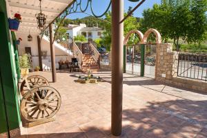 a patio with a fence and a wooden wheel at Villa Cultural MONTELUCÍA in Montecorto