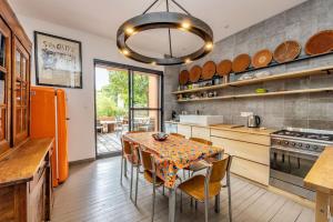 una cocina con mesa con sillas y una gran lámpara de araña en Maison les 3 perles - Hypercentre - Gaillac, en Gaillac