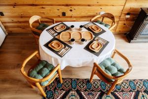 un tavolo bianco con piatti di cibo sopra di Casuta mea a Stulpicani
