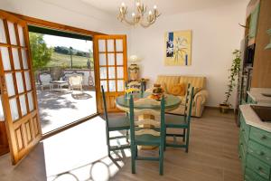 a kitchen and dining room with a table and chairs at Villa Cultural MONTELUCÍA in Montecorto