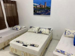 a room with two beds and a picture on the wall at Pousada Coração de Jesus in Aparecida