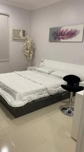 a bedroom with a bed and a chair in it at شقه حديثه بالقرب من المسجد النبوي غرفتين وصاله ومطبخ وحمام تتسع لخمس اشخاص in Al Madinah