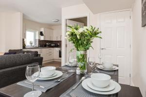 tavolo da pranzo con bicchieri e vaso di fiori di Oxheys House - 5 Bedrooms Contractors Parking a Preston