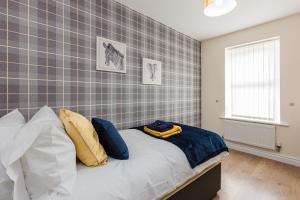 una camera da letto con un letto con cuscini blu e gialli di Oxheys House - 5 Bedrooms Contractors Parking a Preston