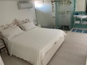 um quarto com uma grande cama branca e um lavatório em Dimora Sorrento em Sant'Agnello