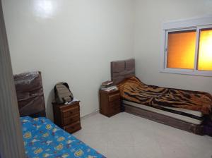 una camera da letto con un letto e una finestra di Family Appart a Martil