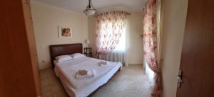 1 dormitorio con 1 cama con sábanas blancas y ventana en Smaragda Sea View Villa, en Karianí