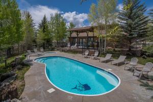 einen Pool mit Stühlen und ein Haus in der Unterkunft Thousand Trails Blue Mesa Recreational Ranch in Hierro