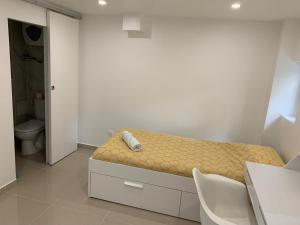 a small bedroom with a bed and a bathroom at Chambre 14m2 in Massy