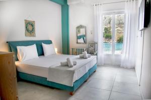 a bedroom with a bed and a large window at Gerolimin Blue in Yerolimin