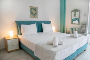 a bedroom with a large bed with towels on it at Gerolimin Blue in Gerolimenas