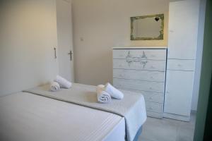 a bedroom with a bed and a dresser with towels on it at Gerolimin Blue in Gerolimenas +19 photos