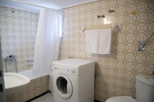 a bathroom with a washing machine and a sink at Gerolimin Blue in Yerolimin