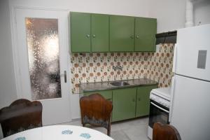 a kitchen with green cabinets and a white refrigerator at Gerolimin Blue in Yerolimin