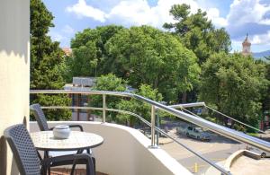 einen Balkon mit einem Tisch und Stühlen sowie Stadtblick in der Unterkunft Apartment Paty in Krk