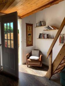 une chambre avec une chaise et un escalier avec une porte dans l'établissement Charmant appartement, à Andernos-les-Bains