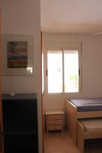 a bedroom with a bed and a window at Bali Solo Familias Serviplaya in Playa de Xeraco