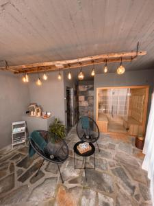ein Wohnzimmer mit 2 Stühlen und einem Tisch in der Unterkunft Rustico con SPA Privata - Piscina - Sauna - Hammam - Free Wi-Fi & NETFLIX in Brossasco