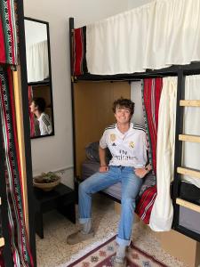 a man sitting on top of a bunk bed at Darna Hostel in Amman