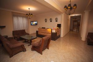 a living room with chairs and a table and a tv at Hotel Irise in Kobuleti